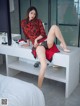 A woman sitting on top of a white bench in a bathroom.