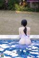 A woman in a purple dress is sitting in a pool.