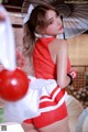 A woman in a red and white outfit holding an umbrella.