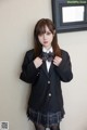 A woman in a school uniform posing for a picture.