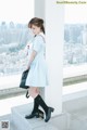 A woman in a school uniform is standing on a ledge.