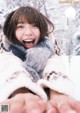 A woman in a white sweater and scarf in the snow.