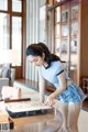 A woman in a blue shirt and denim shorts looking at a map.