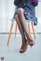 A woman sitting on a chair with her legs crossed.