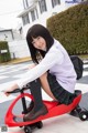 A young woman sitting on top of a red tricycle.