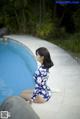 A woman sitting on the edge of a swimming pool.