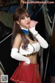 A woman in a white top and red skirt posing for a picture.