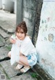 A woman sitting on the ground holding a bag of food.